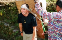 A trekker tries the weight of a porters load